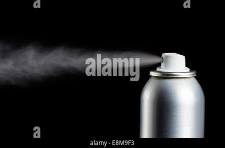 Deodorant can spraying on black background Stock Photo - Alamy