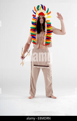 man in fancy dress comedy costume as a native american / red indian with feather head dress and full on outfit, Stock Photo