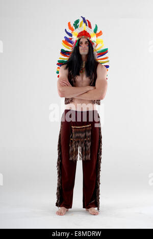 man in fancy dress comedy costume as a native american / red indian with feather head dress and full on outfit, Stock Photo