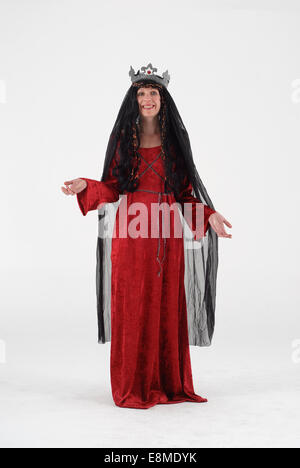 Woman in fancy dress comedy costume in a medieval queen historical outfit with crown, black veil and red dress Stock Photo
