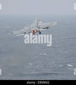 South China Sea, November 23, 2013 - An F/A-18E Super Hornet launches off the flight deck of the aircraft carrier USS Nimitz (CV Stock Photo