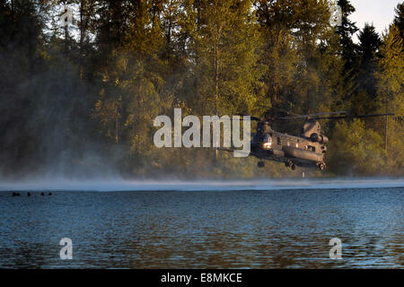 July 14, 2014 - Airmen wait in American Lake for an MH-47 Chinook helicopter to extract them during helocast alternate insertion Stock Photo