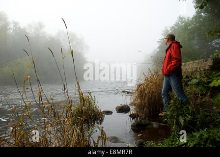 Gainford, County Durham, UK. 11th October 2014. A man looks out at the mist and fog along the upper reaches of the River Tees in County Durham. The mist and fog is expected to clear during Saturday but further mist and fog is forecast for Sunday morning for many areas of the North East. Credit:  Robert Smith/Alamy Live News Stock Photo