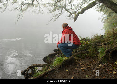 Gainford, County Durham, UK. 11th October 2014. A man looks out at the mist and fog along the upper reaches of the River Tees in County Durham. The mist and fog is expected to clear during Saturday but further mist and fog is forecast for Sunday morning for many areas of the North East. Credit:  Robert Smith/Alamy Live News Stock Photo