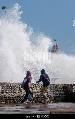 People playing close to breaking waves on Brighton seafront. Stock Photo