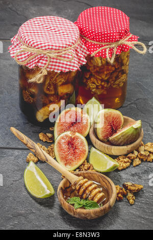 Figs Preserved in Honey Syrup. Honey, walnuts s and dried fruit in jar. Done with a vintage retro filter. Stock Photo