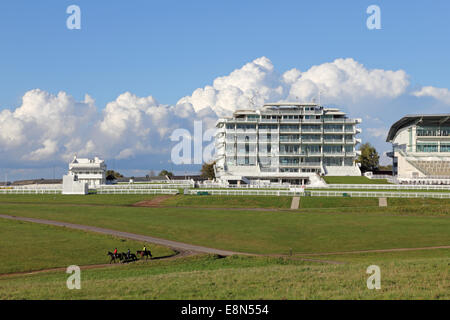Epsom Downs, Surrey, UK. 11th October 2014. Blue skies alternate with dramatic cumulonimbus rain clouds over Epsom Downs Race Course. Three riders make the most of the sunshine to exercise their horses. Credit:  Julia Gavin UK/Alamy Live News Stock Photo
