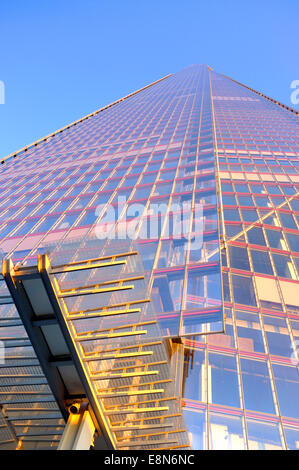 The Shard building in London reflects the pink sunset golden hour glow against a blue sky at dusk Stock Photo