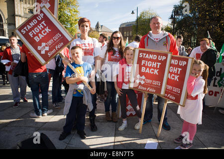 Belfast, Northern Ireland. 11th Oct, 2014. A Family holds placards protesting against Tory Welfare cuts Credit:  Bonzo/Alamy Live News Stock Photo