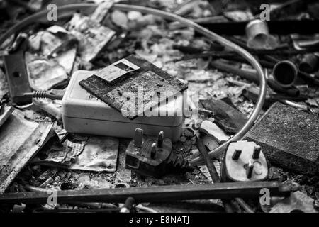 Floppy disk, mains lead with UK 3 pin plug, power supply transformer, burnt documents and other office items after a fire Stock Photo