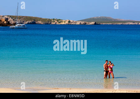 Man and woman on holiday taking a 'selfie' photograph while standing in the sea at Arenal d'en Castell, Menorca, Spain Stock Photo