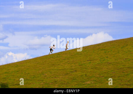 Two young boys running up a hill in Bedfordshire, UK Stock Photo