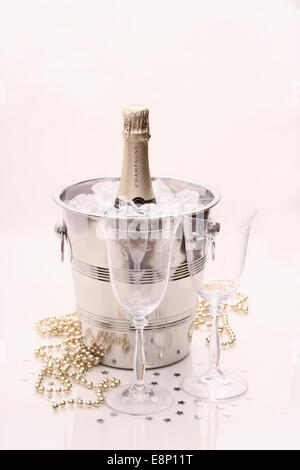 Champagne bottle in cooler, two champagne glasses on bright background Stock Photo