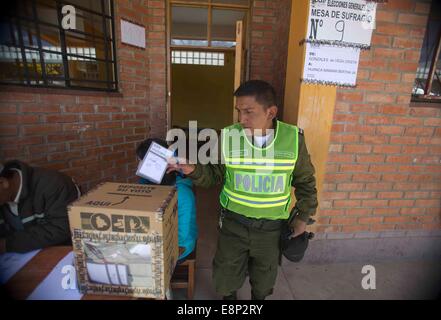 El Alto, Bolivia. 12th Oct, 2014. A policeman casts his vote at a school in El Alto city, Bolivia, on Oct. 12, 2014. Millions of Bolivians casted their votes in general elections for a new president and state legislators on Sunday. Credit:  David de la Paz/Xinhua/Alamy Live News Stock Photo