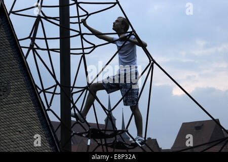Ambition for success. Young man climbing up the rope pyramid Stock Photo