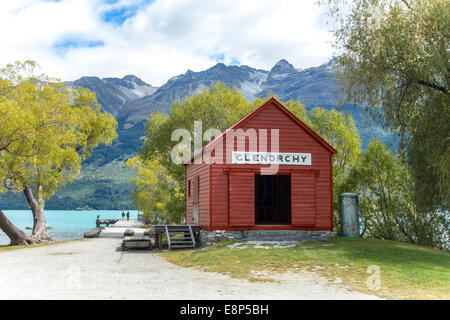 Glenorchy historic boat shed and jetty with a couple, two people, on Lake Wakatipu with The Remarkables, Otago New Zealand Stock Photo