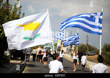 Astromeritis, Cyprus. 12th Oct, 2014. Young students holding Cyprus and Greece Flags on their way to Astromeritys chech point in the anti occupation event of Morfou municipality in Astromeritys Village.The anti-occupation commemoration yearly was held in Morfou municipality after its Turkish invasion in 1974. Credit:  Yiorgos Doukanaris/Pacific Press/Alamy Live News Stock Photo