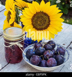 Homemade plum jam with freshly picked plums on wooden table Stock Photo