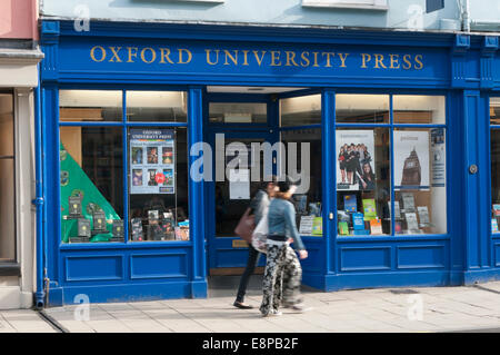Two people (motion blurred) passing the Oxford University Press Bookshop in the High Street, Oxford. Stock Photo