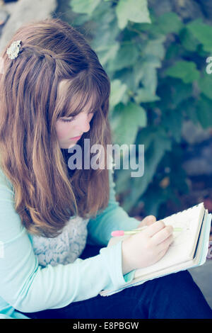 Portrait of teenage girl (13-15) writing Stock Photo