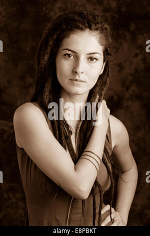 Portrait of young woman with dreadlocks, with right hand on shoulder Stock Photo