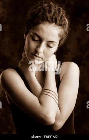 Portrait of young woman with eyes closed and hands on neck Stock Photo