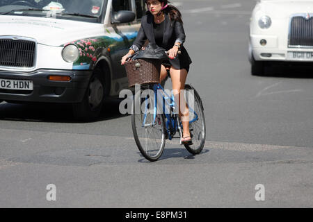 A female cyclist riding in London traffic Stock Photo
