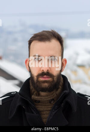 Portrait of a shocked young bearded man in the winter scenery Stock Photo