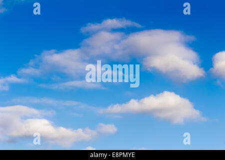 White fluffy clouds float on the blue sky in a clear sunny day. Stock Photo