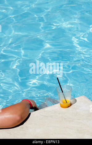 Reading a book by the pool with a cold drink during the hot days of ...