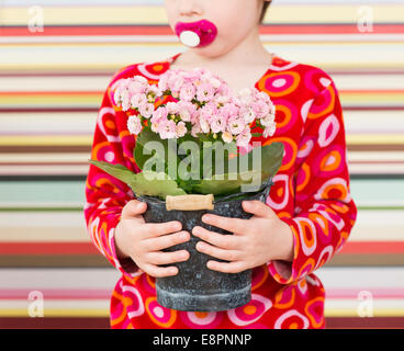 Little girl with red dress holding flower in flowerpot Stock Photo