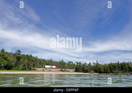 Cargo truck on Trans Canada Highway under cloud blue sky Stock Photo