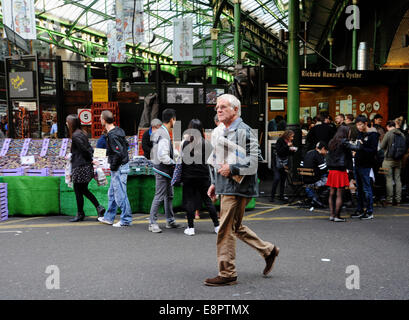 London Southwark UK - Man carrying newspaper through Borough Market London Southwark UK Stock Photo