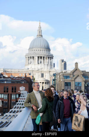 London UK - Visitors cross the Millennium footbridge with St Paul's Cathedral in the background Stock Photo