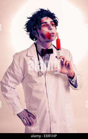 a scary zombie doctor with a syringe with blood, with a filter effect Stock Photo