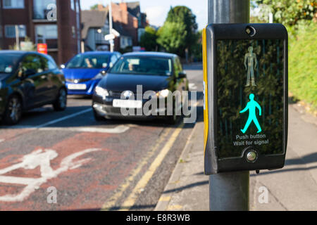 Green man sign illuminated at a puffin crossing while cars wait, Nottinghamshire, England, UK Stock Photo