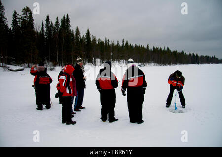 Lapp guide demonstrating traditional ice fishing technique on Lake Pyhajarvi, Kairos, Finland. Stock Photo