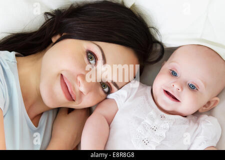 Happy smiling mother with six month old baby girl indoor Stock Photo