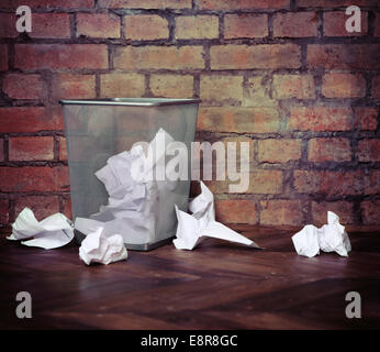 Recycle bin filled with crumpled papers. Brick wall background. Retro style Stock Photo
