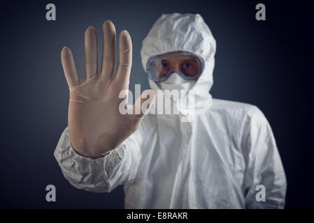 Medical Health Care Worker Showing Stop Sign with hand, entrance is forbidden in quarantine zone. Stock Photo