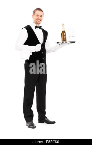 Full length portrait of a professional waiter holding a tray with a champagne and two glasses on it isolated on white background Stock Photo