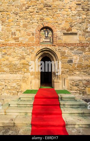 Red carpet in front of an orthodox church in Borzesti, Romania, near Onesti. The church was made by king Stefan cel Mare in 1493 Stock Photo