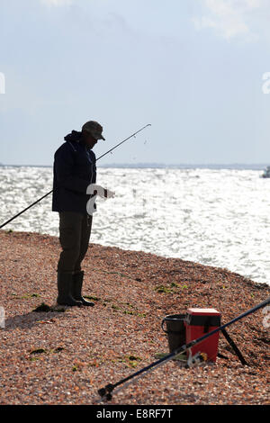 Semi silhouette of beach fisherman baiting a hook. Stock Photo