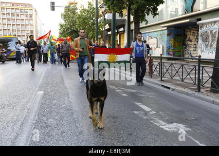 Athens, Greece. 13th Oct, 2014. A stray dog leads the protest, ahead of the Kurdish flag. Kurds living in Greece protested against the attacks of the Islamic State (IS) on the city of Kobane in Syria.Their anger was mostly directed towards the inactivity of Turkish Army to aid the besieged city. Credit:  Michael Debets/Pacific Press/Alamy Live News Stock Photo