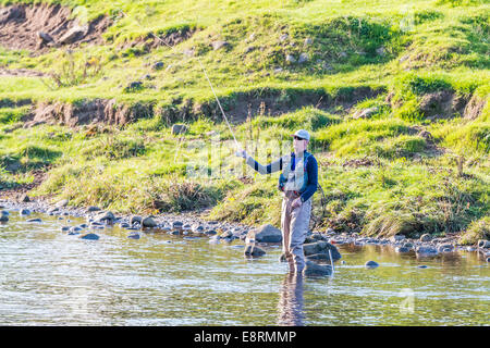 Fly fisherman angler in the River Wharfe at Bolton Abbey, North Yorkshire Stock Photo