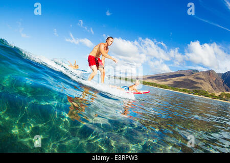 Father and Son Surfing Together Riding Blue Ocean Wave Stock Photo