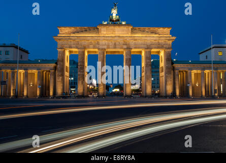 Car light trails streak in front of the Brandenburg gate in the evening. Berlin Stock Photo