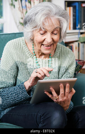 Senior Woman Using Digital Tablet At Home Stock Photo