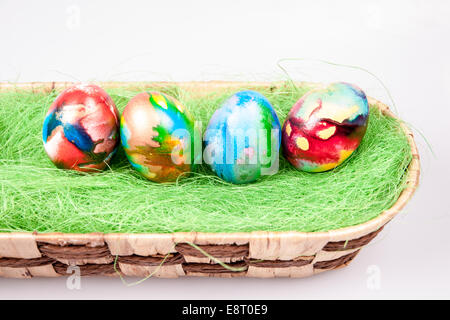 Colorful E|aster eggs in wicked bascet on a white background Stock Photo