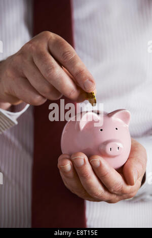 Hand putting coin piggy bank growth chart Stock Photo - Alamy